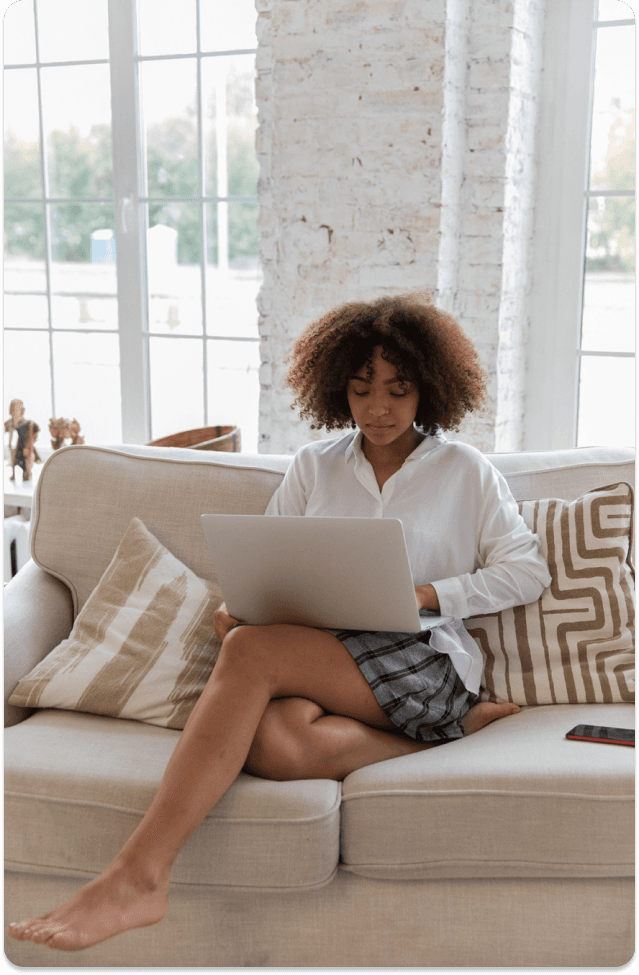 image of a woman sitting on couch with a laptop on her lap